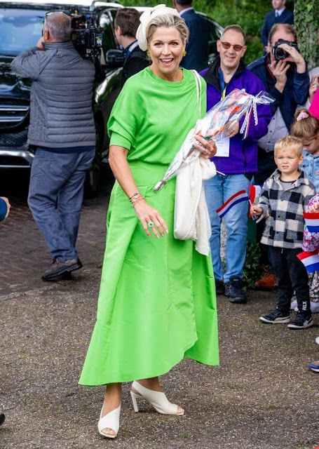Queen Maxima wore a new green midi dress by Natan, and beige trench coat by Max Mara. Green earrings