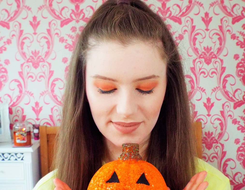 Looking down toward pumpkin in hands, showing long delicate lashes