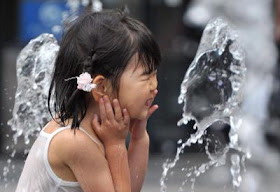 A girl plays in a water fountain