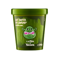 A big dark green cylindrical tub  with a black rectangular label with a green ogres face on the front with get outta my swamp shower slime in green font with lush x Shrek in green font on a bright background