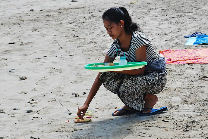 Mujer quemando incienso en la playa