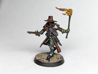 Haskel hexbane, painted with green clothing and brown leathers. He has a pistol in one hand and a burning brand in the other.