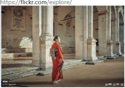 woman in orange kimono at center of colonnaded courtyard