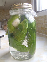 A jar of pickles with garlic and dill