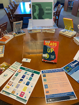 Mental Health Awareness Month display. Table with flyers and books