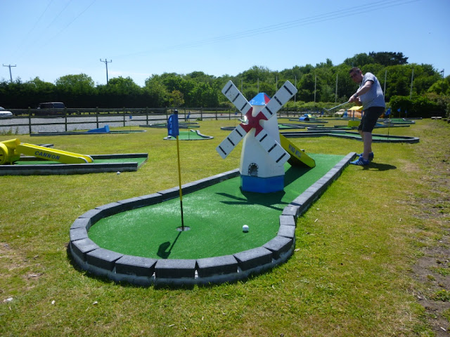 Playing the windmill hole on the Crazy Golf course at Penwith Pitch & Putt in Cornwall