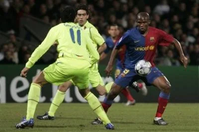 Barcelona striker Samuel Eto'o challenges for the ball with Lyon's Fabio Grosso