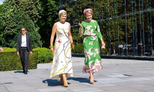 Queen Maxima wore a hand-painted silk and cotton shantung dress by Natan. Queen Mathilde wore a floral print maxi dress by Natan