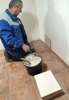 First wall tile being positioned