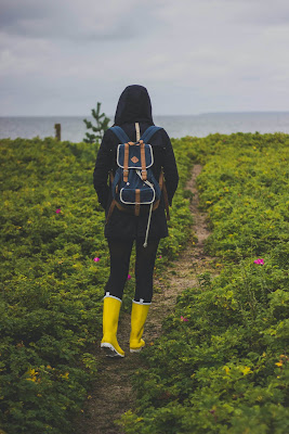 picture of a woman with yellow hiking boots and a backpack