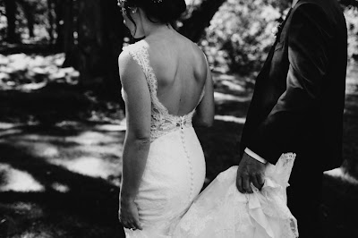Novio ayudando con la cola del vestido a la novia