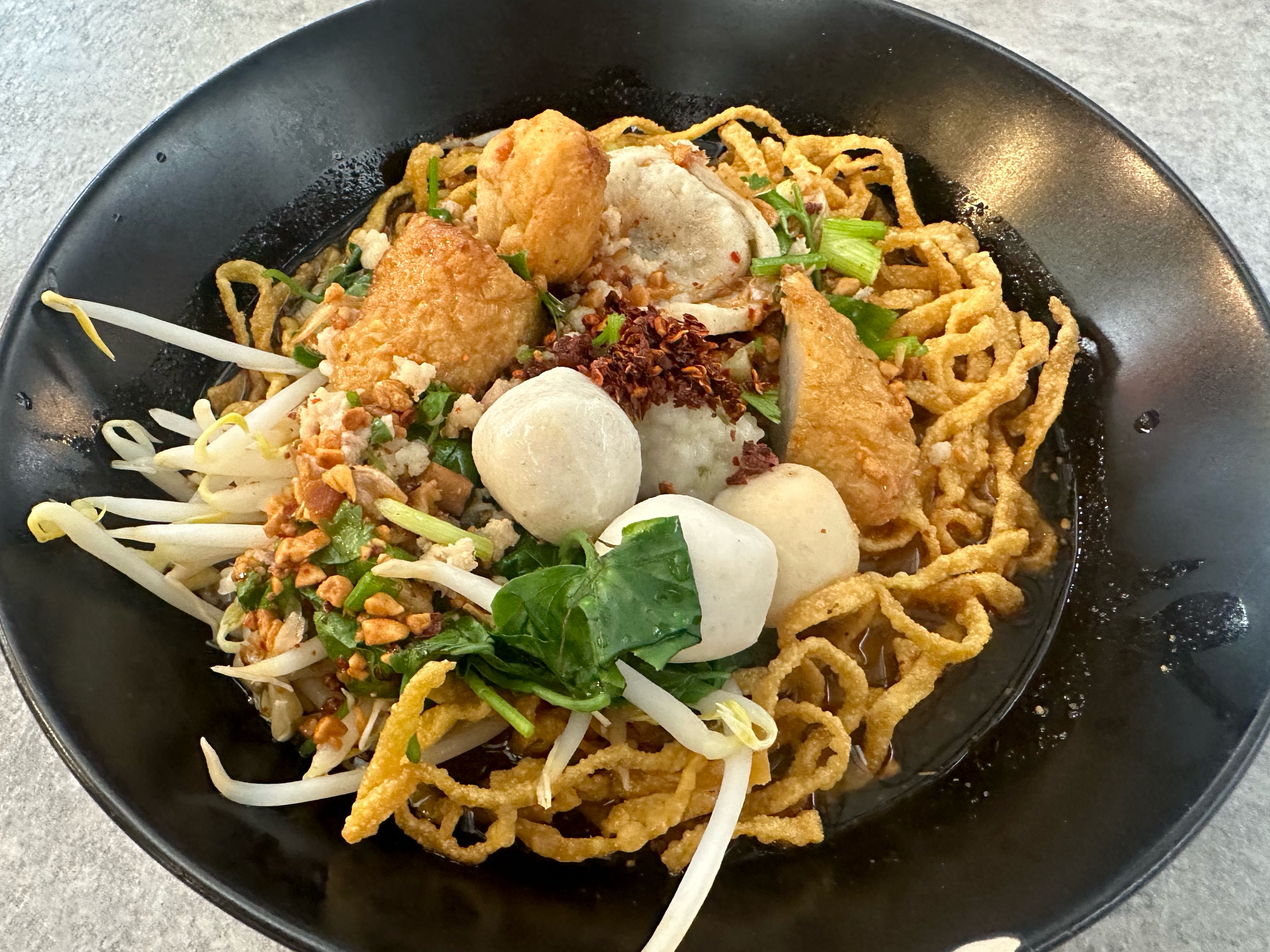 crispy tom yum noodles with fish balls in Bangkok, Thailand