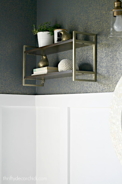 Wood and brass shelves above toilet 