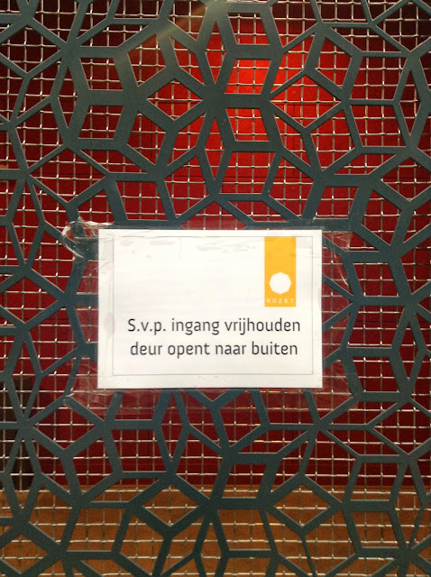 Toegang fietsenkelder Rozet, Arnhem. geplastificeerd bordje met de tekst'S.v.p. ingang vrijhouden, deur opent naar buiten'. Foto: Robert van der Kroft, 4 april 2014