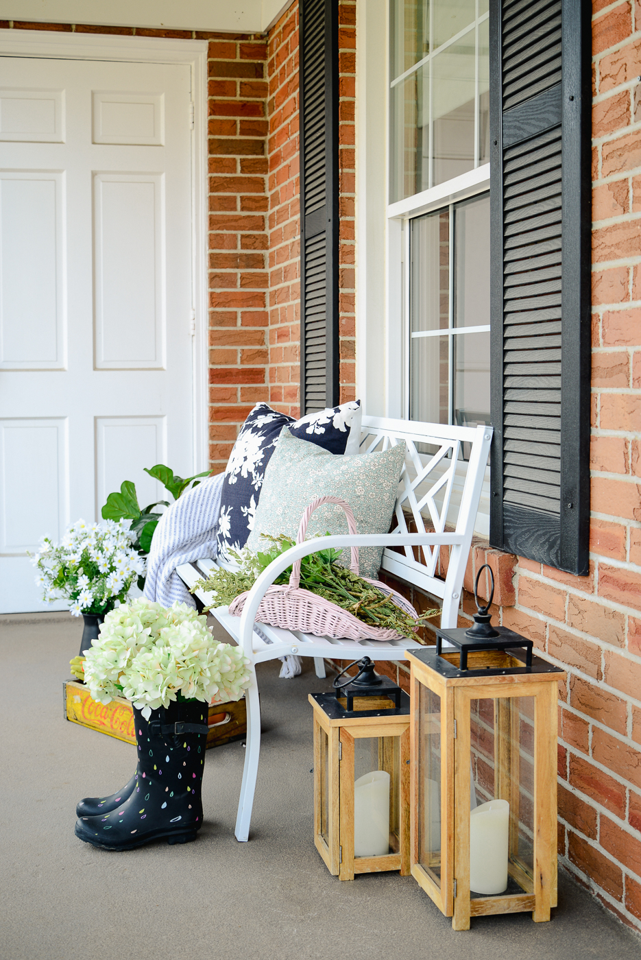 white outdoor porch bench with white flowers, hydrangeas in rain boots