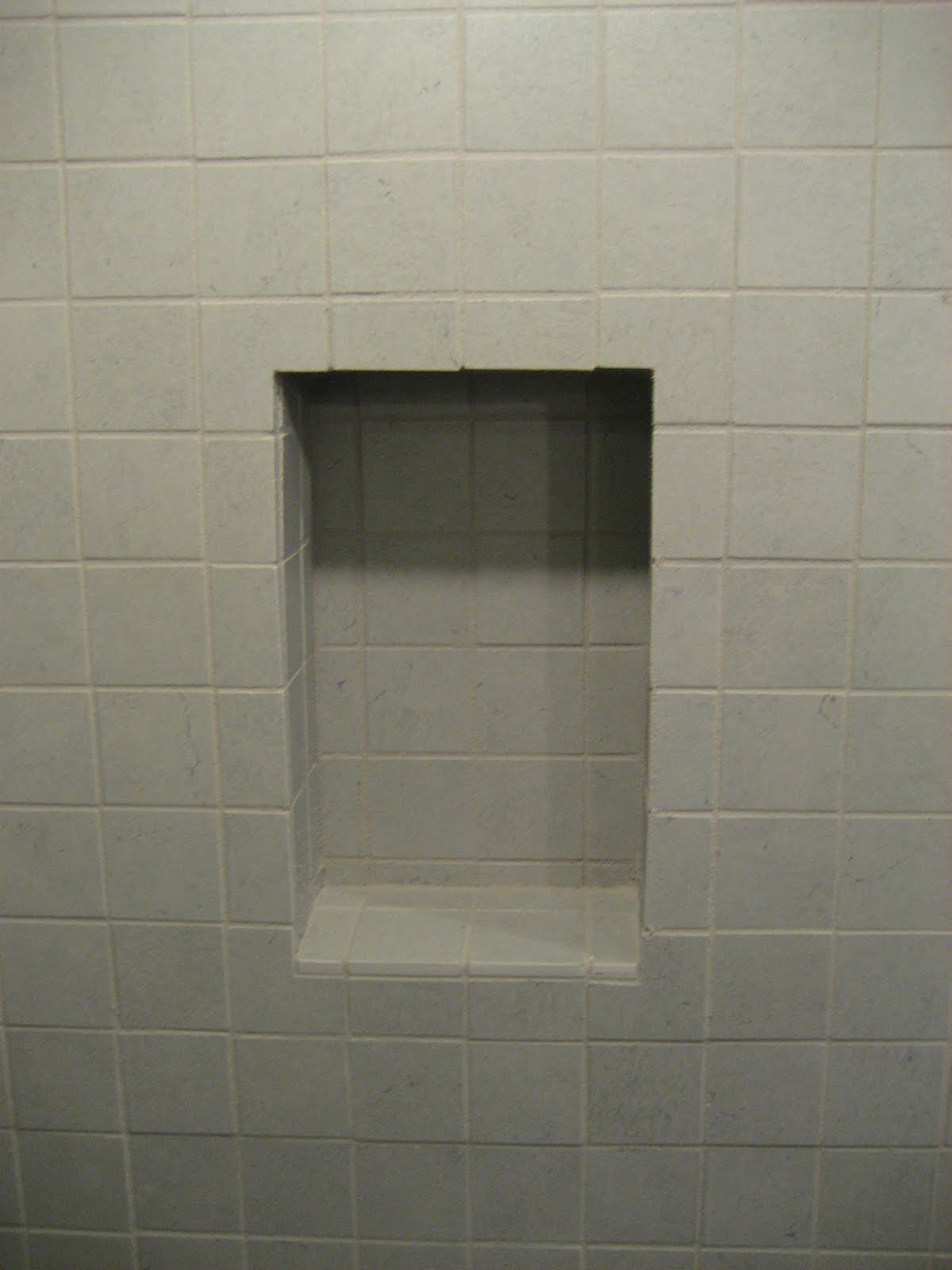 glass shower walls Putting the grout in this shampoo recess was a challenge.