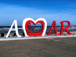 A foto mostra o letreiro do verbo Amar na praia de Tramandaí-RS.