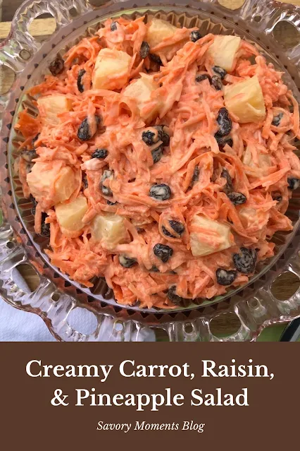 Serving bowl full of creamy carrot, raisin, and pineapple salad.
