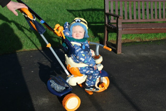 toddler on bike with eyes shut because of the sun