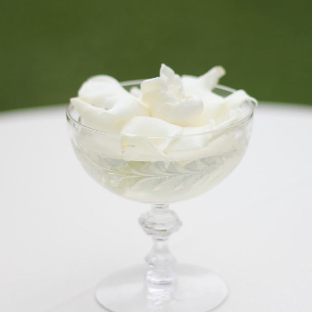 sweet pea floral design ann arbor detroit misty farms wedding fruit farms Cocktail tables featured gardenia floating in vintage crystal ice cream goblets.