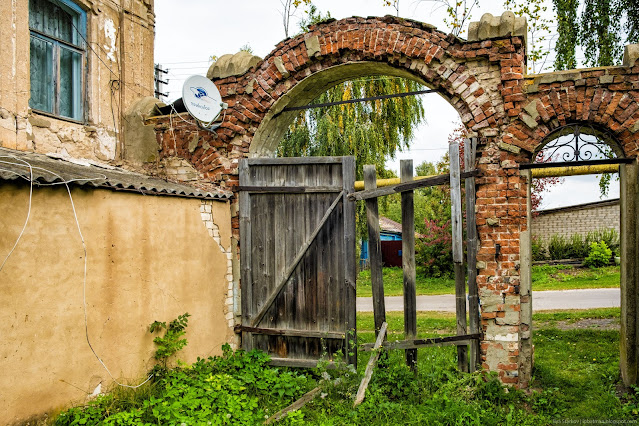 Старые кирпичные, арочные ворота у здания