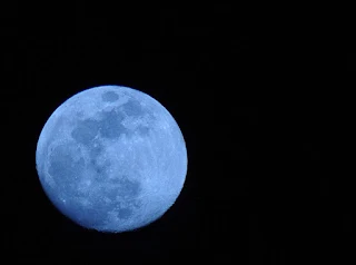 Volcanoes and forest fires adds a bluish tinge to the Moon.