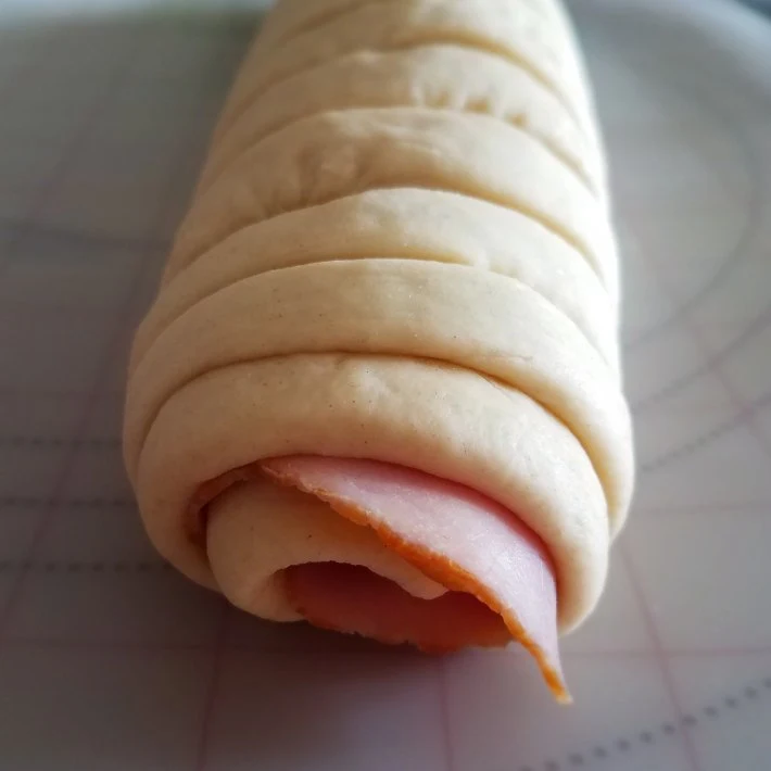 Pan de jamón con el relleno sobresaliendo en los extremos