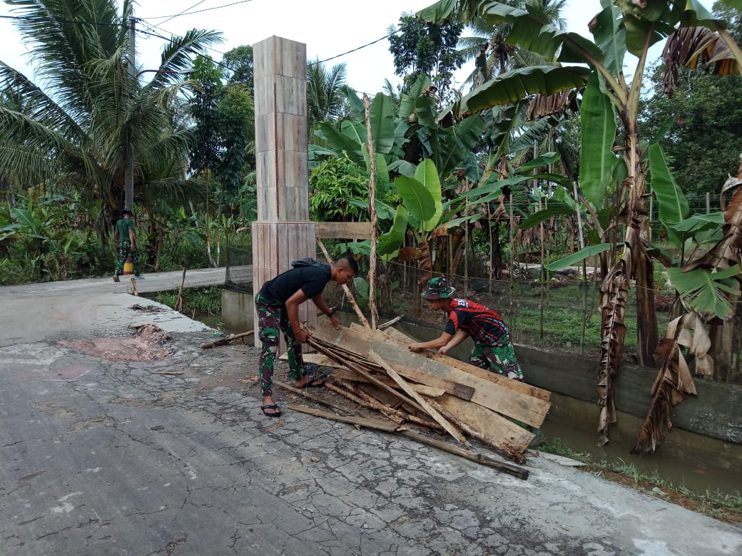 Rapikan sisa pengerjaan gapura di depan pintu masuk kampung Jawi.