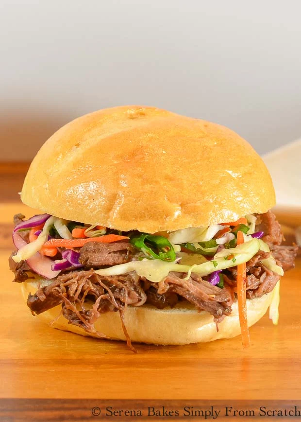 Slow Cooked Korean Pulled Beef Sliders. Tender shredded Korean Pulled Beef piled high on a warm bun and topped with Asian Coleslaw from Serena Bakes Simply From Scratch.