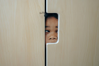 https://www.pexels.com/photo/playful-black-little-girl-hiding-in-closet-4545972/