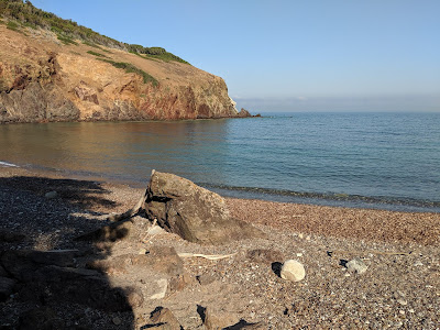 Spiaggia dei Mangain and the red Punta dei Mangani.