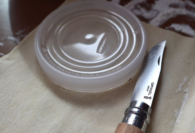 plastic lid on top of puff pastry and knife for cutting