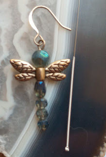 Picture of blue beaded earring and single acupuncture needle