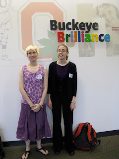 A photo of Noranne and Melanie standing in front of a sign that says Buckeye Brilliance