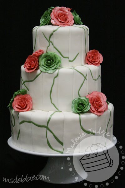 white fondant wedding cake green swirls with green and pink roses