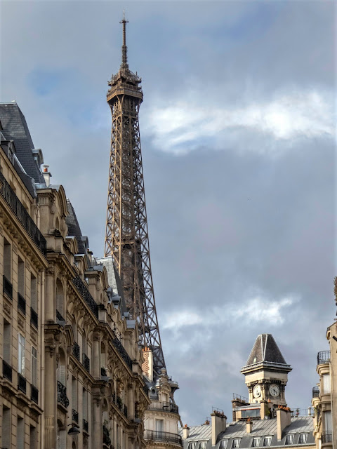 buildings on street with Eiffel Tower in background