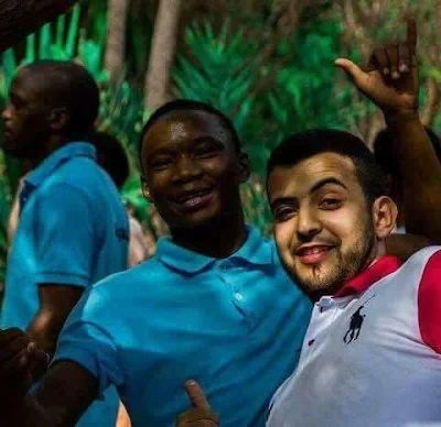 مواطنين ليبيا يقوم باخذ صور السفلي مع العماله الافريقية رد على اتهامات باريس