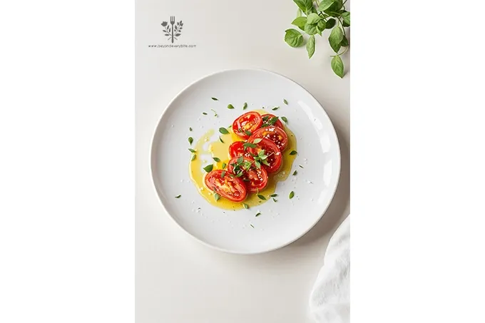 Tomato confit plated with vibrant basil oil drizzle and microgreens.