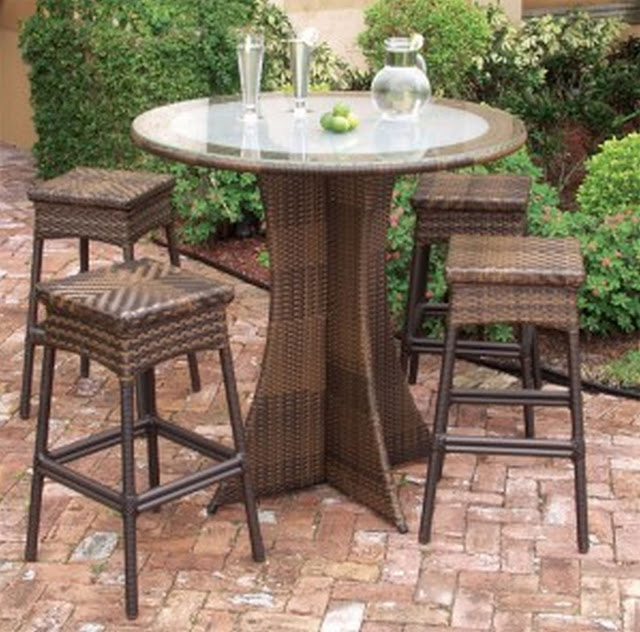 an exotic brown rattan plait round outdoor coffee table with classic leg and four wicker chairs surrounding it beside the green park