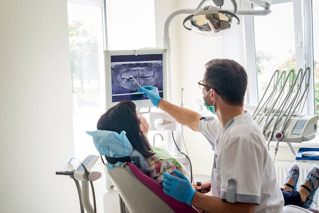 Dentist showing the Cone Beam X-ray to patient