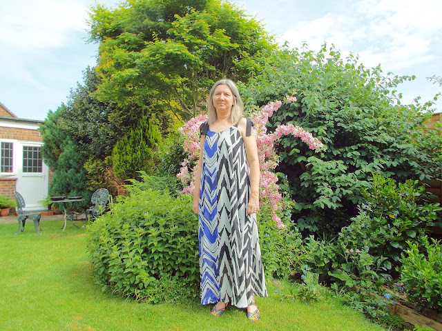 Navy and black zig zag dress  from JD Williams website modelled in a green and leafy garden