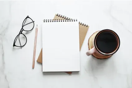 Notepad, eyeglasses, and coffee still life
