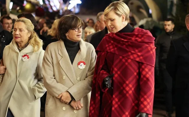 Princess Charlene wore a red ripple check draped coat by Burberry. Princess Stephanie and Melanie de Massy