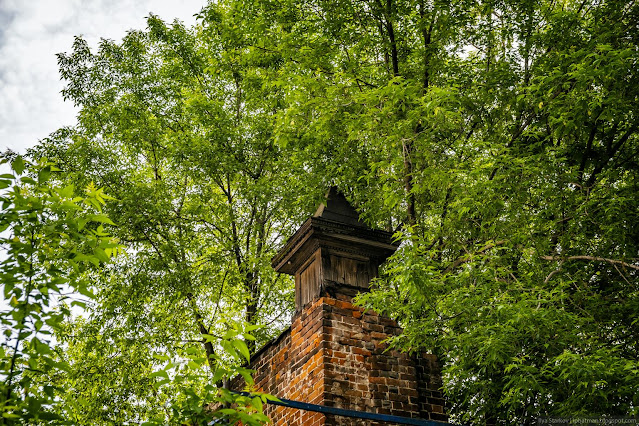 Старая декоративная, деревянная башенка на кирпичной стене