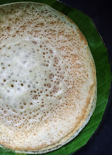 "Stack of freshly made Appams on a plate, showcasing their soft, fluffy texture and golden edges, a beloved accompaniment in Tamil Muslim cuisine."