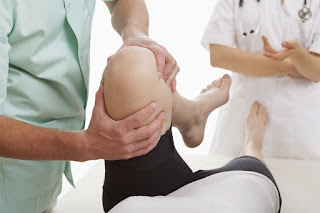 A woman getting her legs examined by two doctors