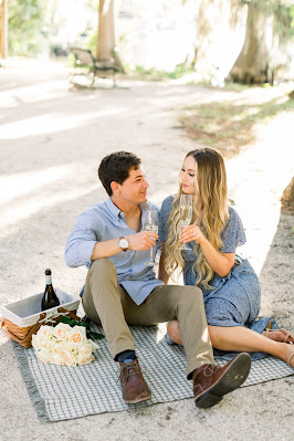 couple sitting on a blanket with champagne
