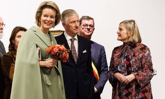 Queen Mathilde wore a sea green wool cape coat and sea green midi dress by Natan. Belgian painter James Ensor