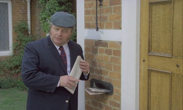 Harry Secombe standing outside the front door of a house