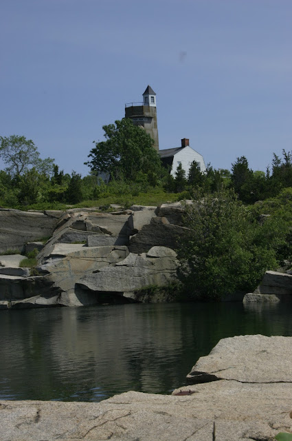 A view across the water filled quarry looking at the museum at Halibut Point State Park.